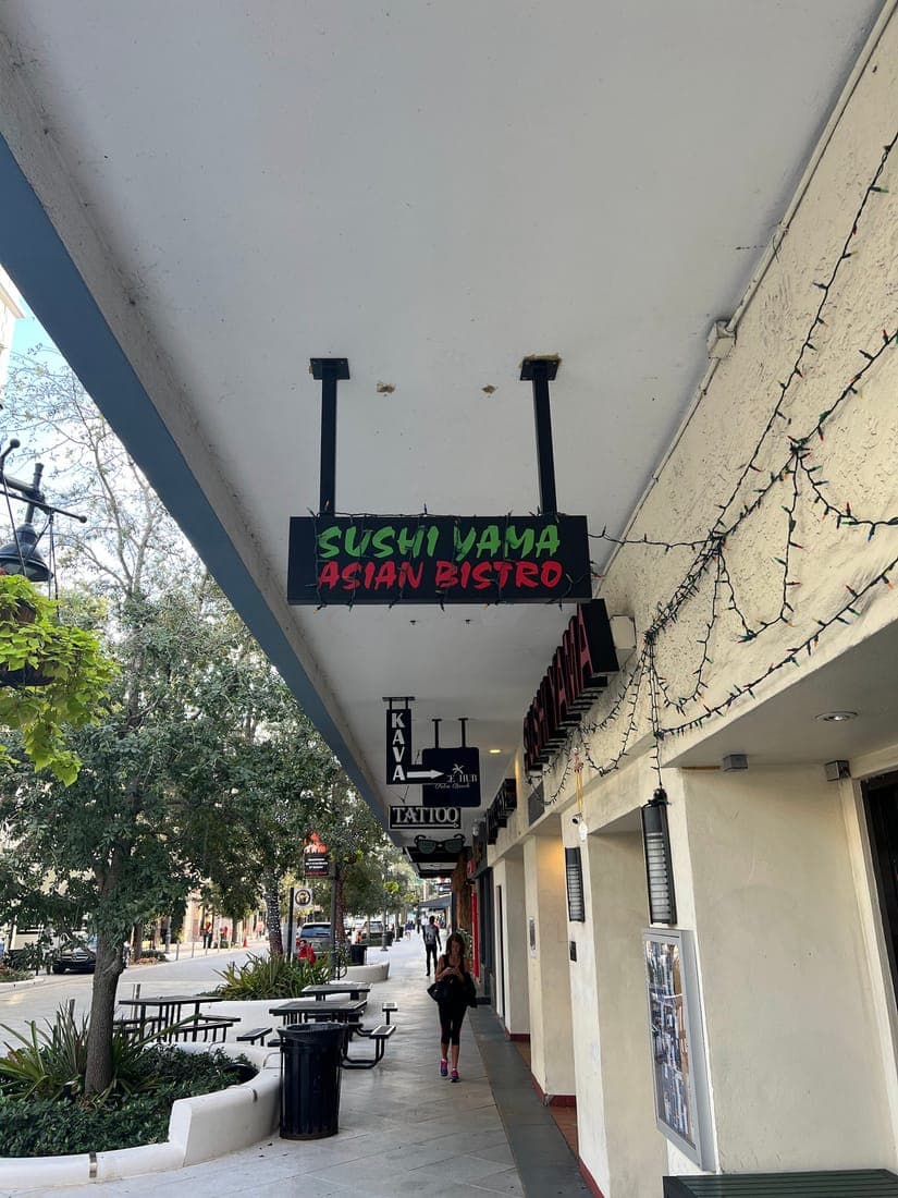 Hanging blade sign over a downtown sidewalk