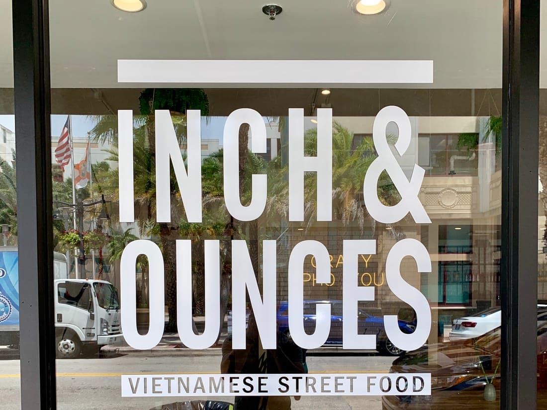 Large vinyl lettering on a restaurant's glass door