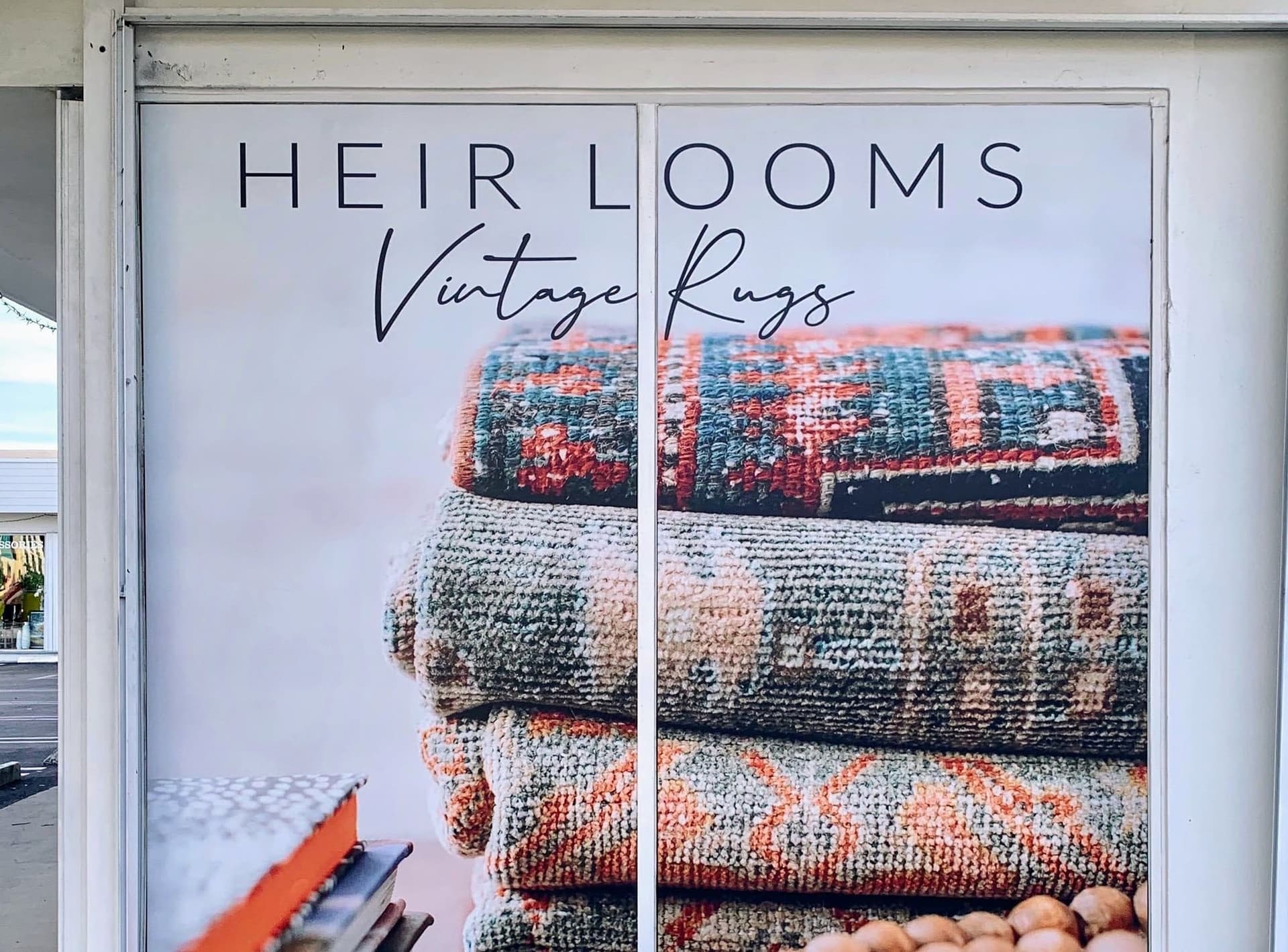 A full-height window graphic of stacked vintage rugs