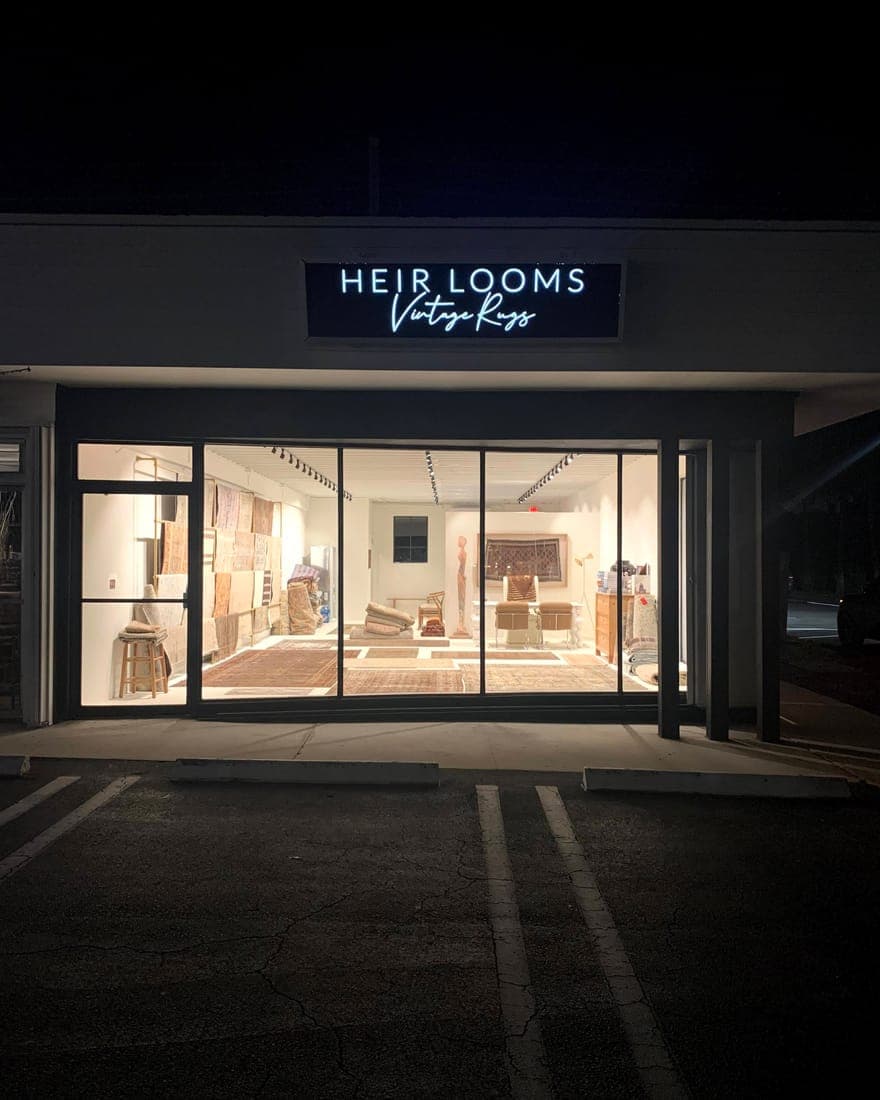 A backlit sign over a storefront entrance