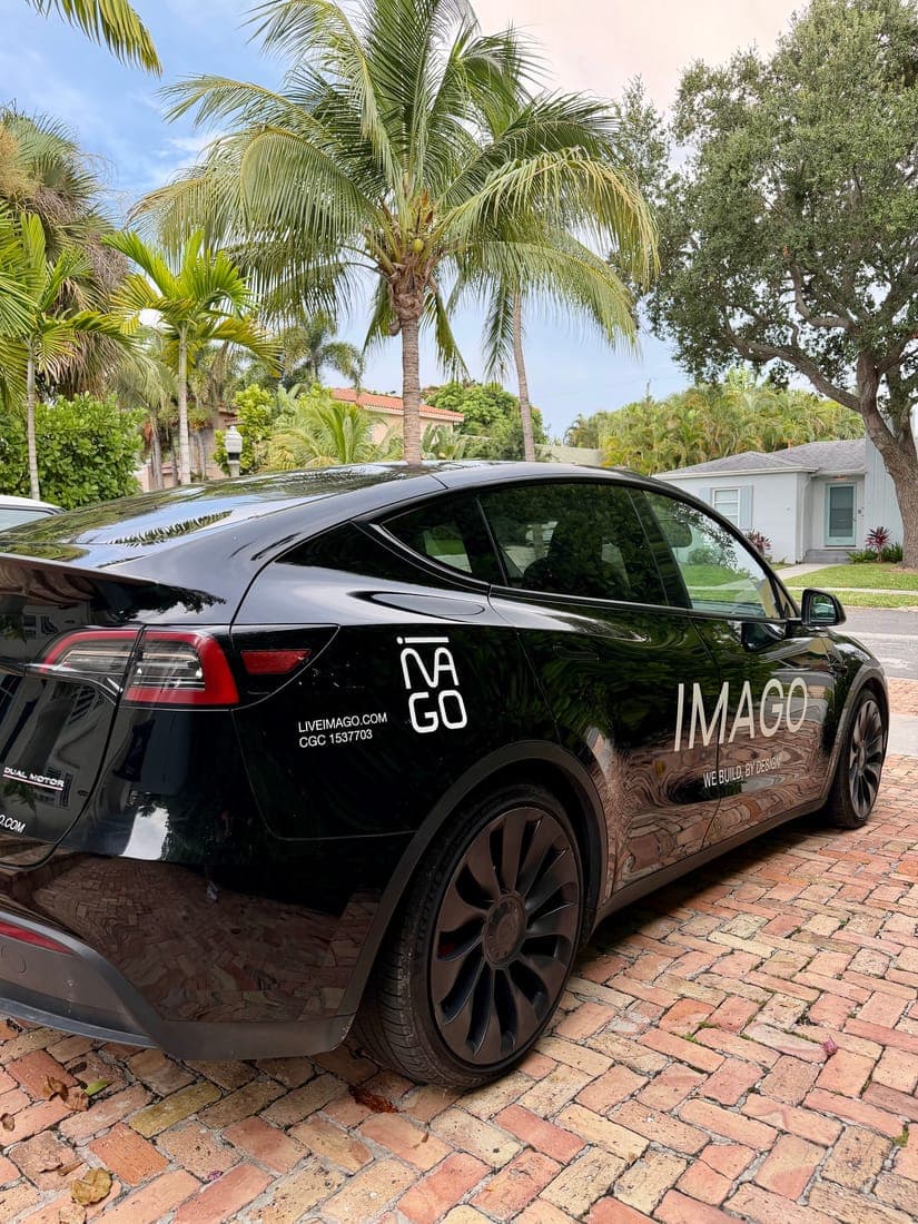 A black sedan with white door and quarter panel graphics